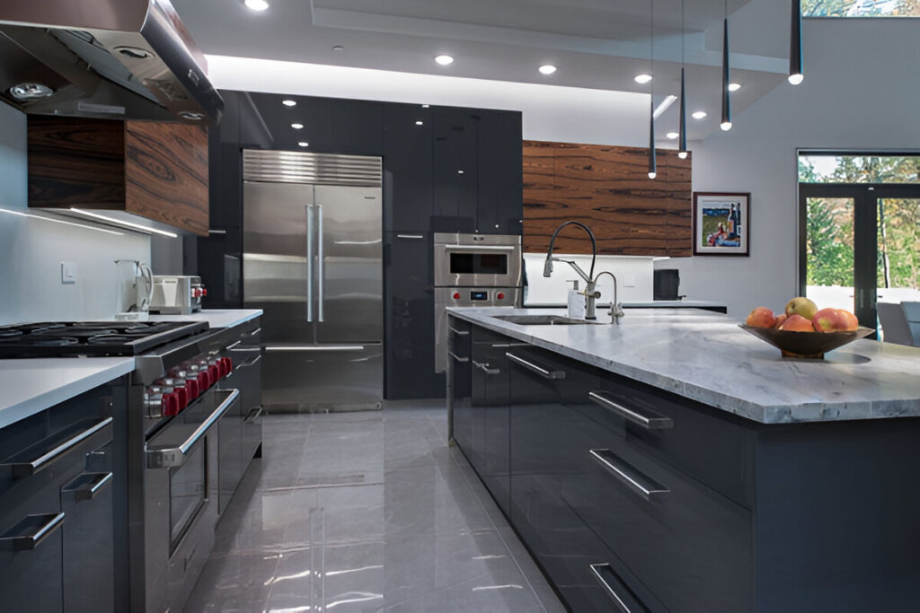 مطبخ مودرن يجمع بين الخشب الداكن والأجهزة الفولاذية اللامعة مع إضاءة حديثة وتصميم أنيق